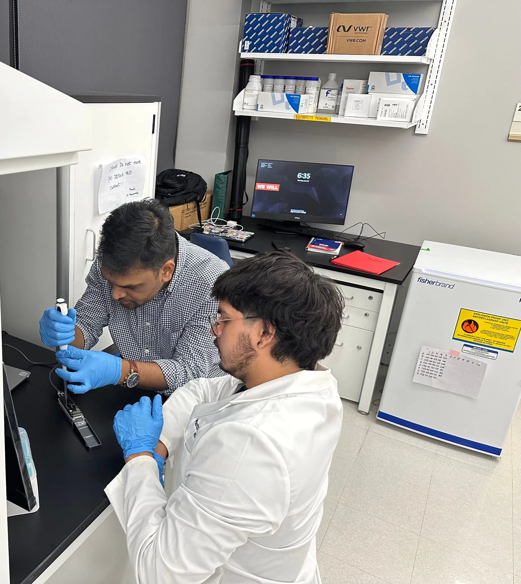 Mentor and student working inside a biosafety cabinet